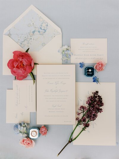 styled wedding invitation flat lay on blue backdrop with blue floral envelope liner, pink florals in Memphis, Tennessee