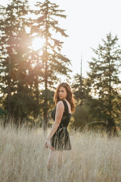 Young woman standing in a tall grassy field in Seattle.