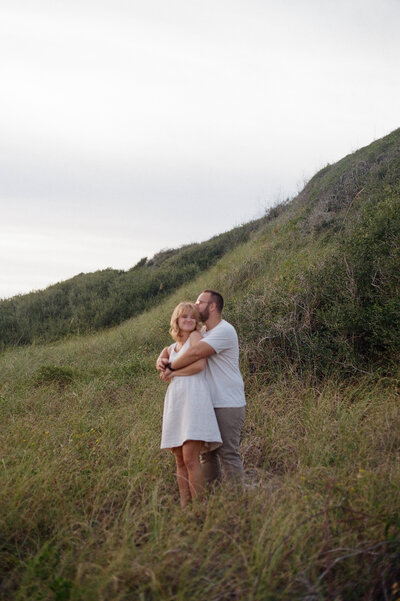 Anna and Alex Williams, creators of Williams Photo and Film holding each other romantically