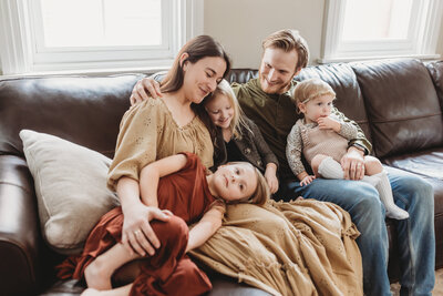 Family of five cuddling on a couch in Harrisburg, PA