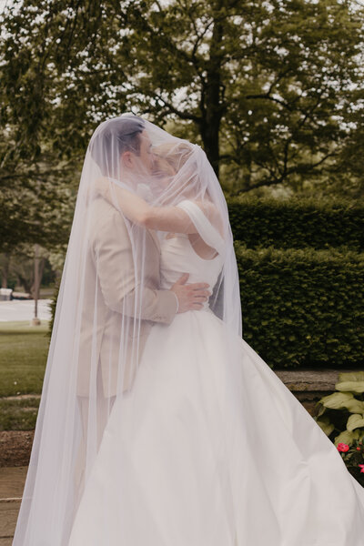 Bride and groom embracing outdoors under a tree