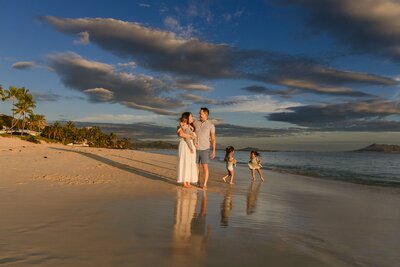 A family of five on a beach at sunset.