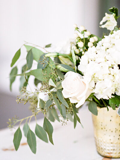 Wedding Floral centerpiece with white flowers and greenery in a gold pot