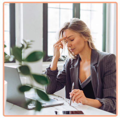 corporate mother in office holding head in frustration