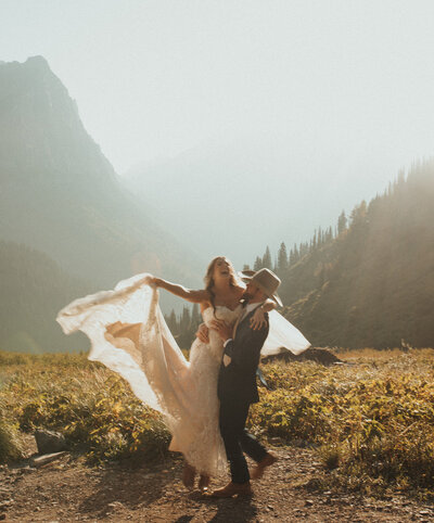 couple dancing together in the mountains after wedding ceremony