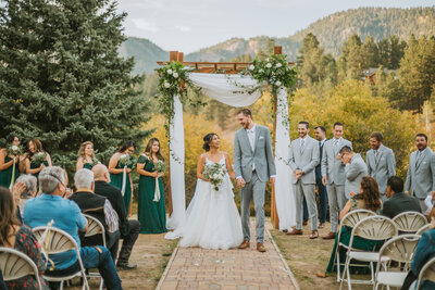 Bride and groom walking down the aisle together after their wedding at Mountain View Ranch in Pine, Colorado, celebrating their new marriage.
