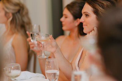 wedding guest holding champagne coupe during wedding toast