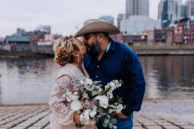 Nashville Elopement Photographer captures couple kissing at river