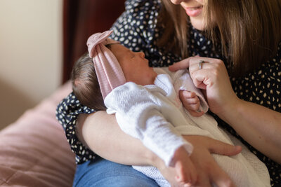 mother gently touches newborn during in home newborn session.