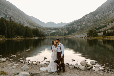 a couple and their dog lakeside after their elopement ceremony