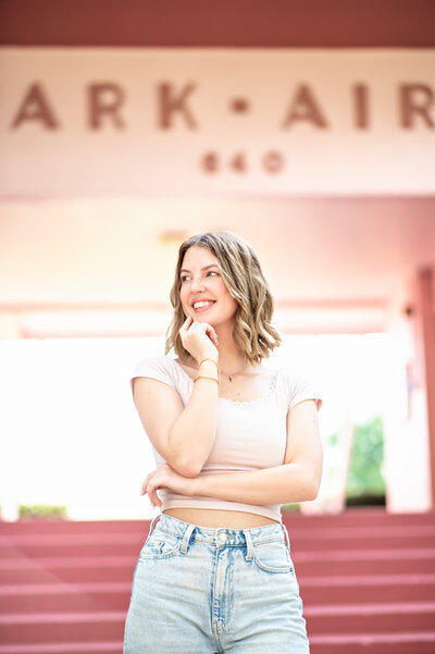 high school senior girl with short blonde hair standing in front of pink stairs and building in winter park, shot by Melissa Vinsik Photography - Orlando Senior Photographer