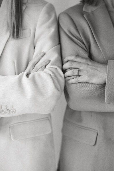 Two women with arms crossed in neutral suits, brand photography, marketing agency photography, social media management, social media strategists