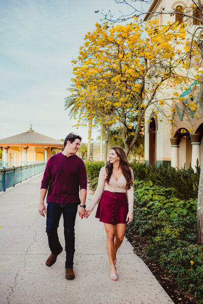 Young couple holding hands and walking on paved path