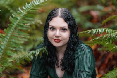 A young girl is surrounded by ferns in a State Park in Portland, OR