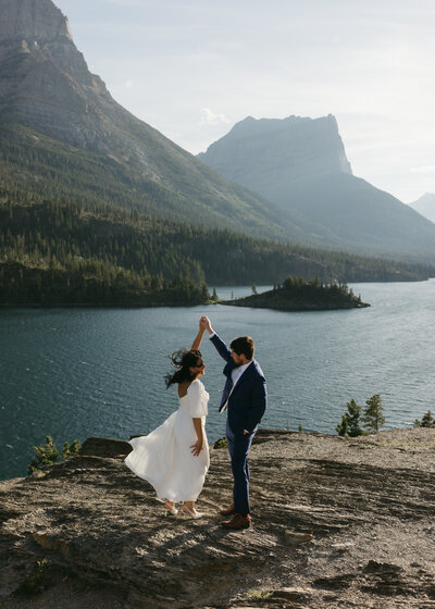 Groom spinning bride at sun point in glacier national park
