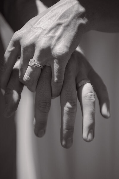 candid of couple holding hands with the ring detail