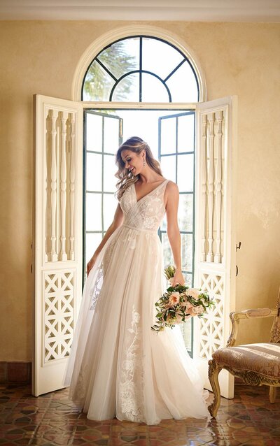 STRAPLESS LACE BALLGOWN WITH FLORALS AND GLITTER TULLE Shower your wedding day look with a sparkling romance! Style 7077 from Stella York is fresh elegance with a luxurious twist. A deep V-neckline with a rounded sweetheart finish adds a distinctly modern feel to the strapless bodice, while cascading floral lace appliques gently draw the eye in toward the waist to flatter the figure. These laces extend in an organic fashion over the rich tulle skirt, featuring multiple grades of glitter tulle to both amp up the shine and dimension of this uniquely fashion-forward piece. This gown zips closed beneath fabric-covered buttons, and is also available in plus sizes.