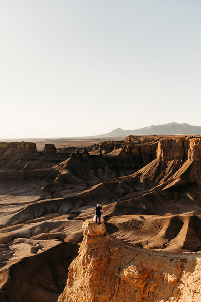 bride and groom walking in red rocks