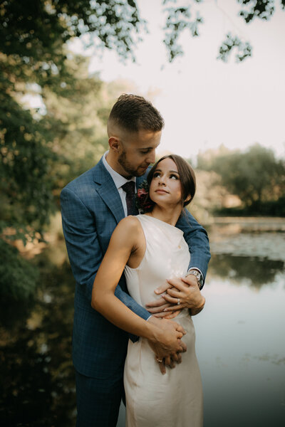 Dakota embracing Whitney by the water during their intimate elopement at North Avenue Pier, captured in warm natural light.