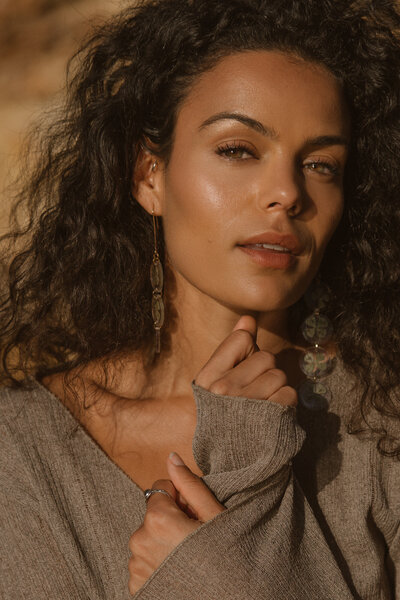 Woman with curly hair looks into the camera for a photoshoot in Ibiza