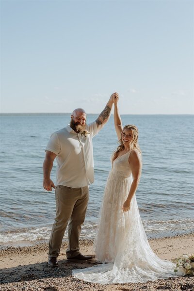 bride and groom celebrating by holding up hands together after ceremony