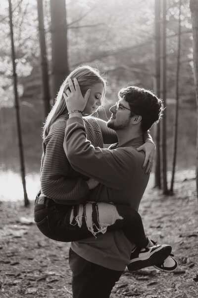 couple embracing in the woods at sunset