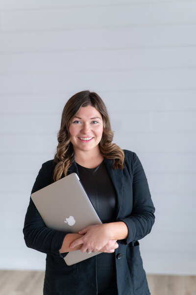 Sarah Hawk, web designer, sitting at her desk with her laptop and coffee