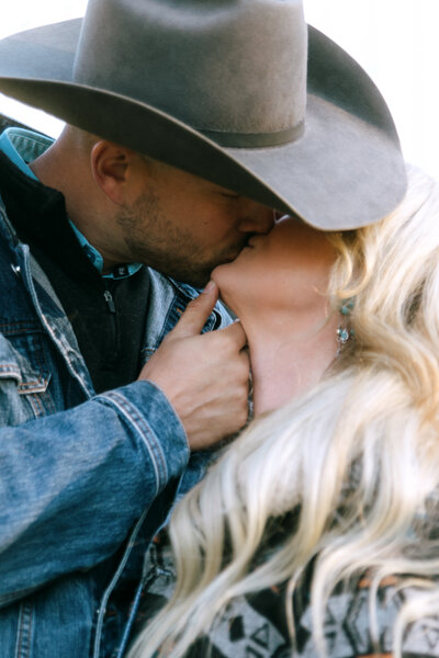 couple kissing each other during western themed photoshoot