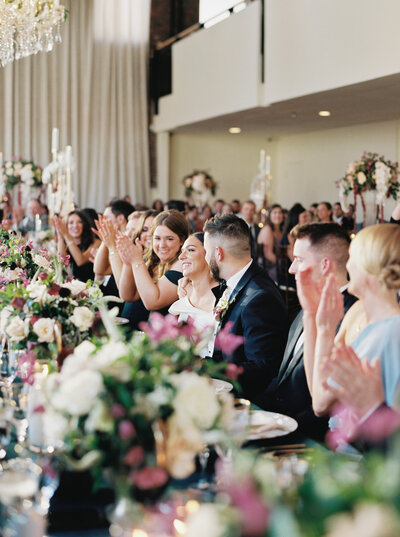 wedding guest clapping for the bride and groom at their reception