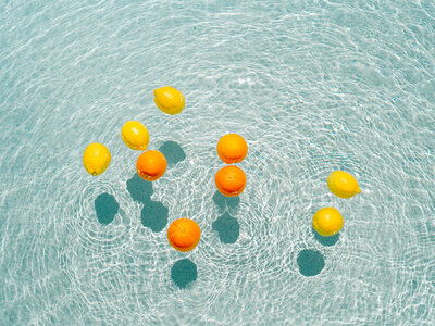 Lemons and oranges floating in pool