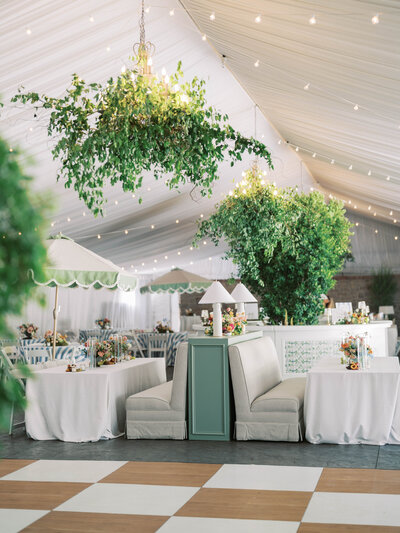 Luxury wedding photography capturing a beautifully set garden reception dinner under a canopy, featuring elegant floral arrangements.