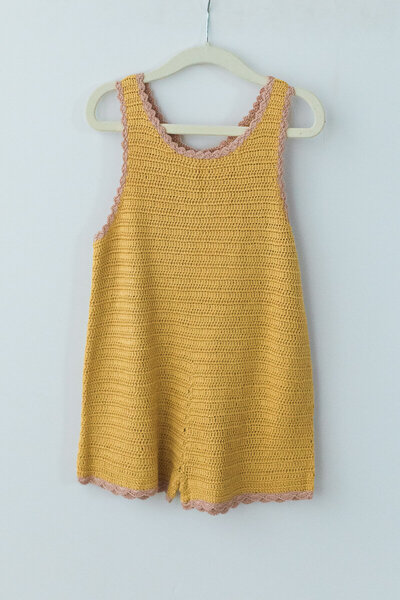 yellow knit romper for girls with pink details