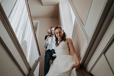 Happy bride and groom walking down the stairs at Woodruff Fontaine House