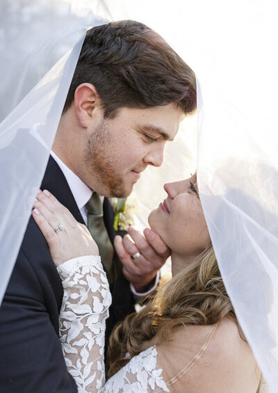 bride and groom embracing under veil