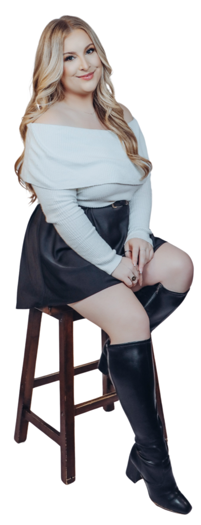 Woman smiling and leaning up against one arm of a chair.