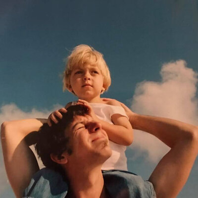son-on-father's-shoulders-clouds-in-sky-bang-images