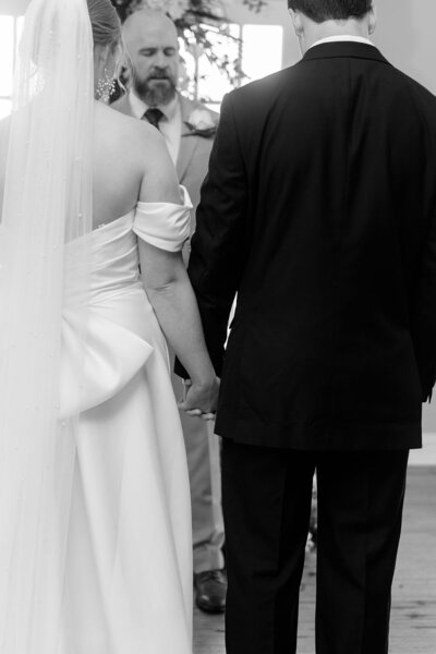 Bride and groom holding hands on their wedding day facing the officiant — Madison Abernathy Photo