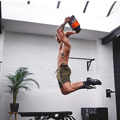 Guy jumping with QNT powder supplement in his hands, symbolizing energy and vitality, crafted by Muse Studio for fitness and wellness brand promotion.