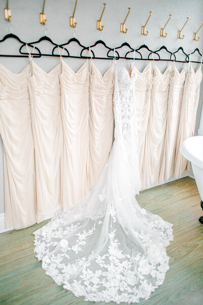 The wedding gown and accompanying bridesmaids dresses all hanging in the bridal suite.