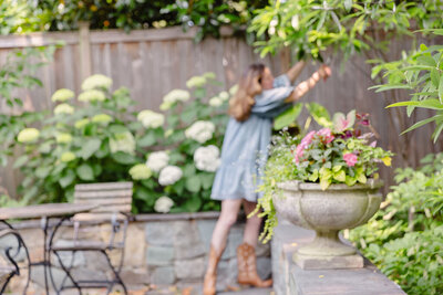 Woman trimming bushes in clean professionally designed back patio
