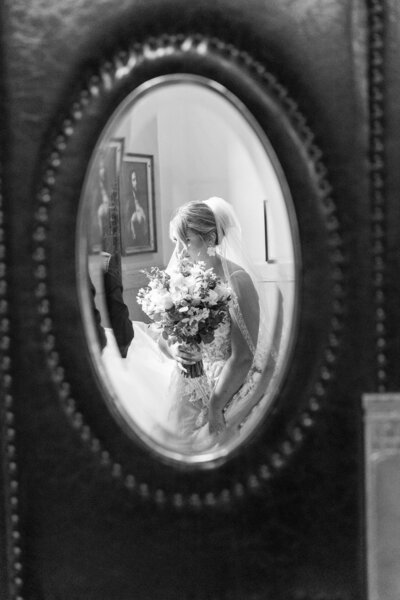 Bride holding flowers in reflection of a mirror