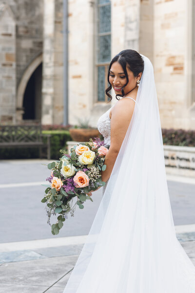 Bride smiling in wedding gown with bouquet during Philadelphia wedding