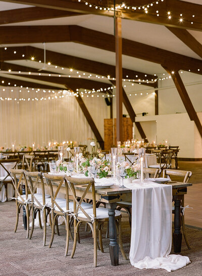 large table with chairs and white table cloth at wedding reception