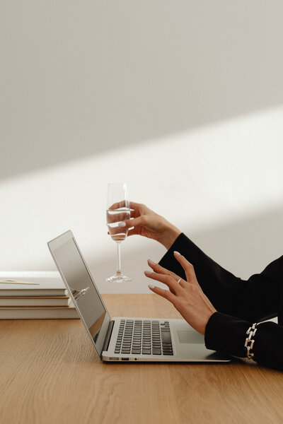 Woman on her laptop with white wine