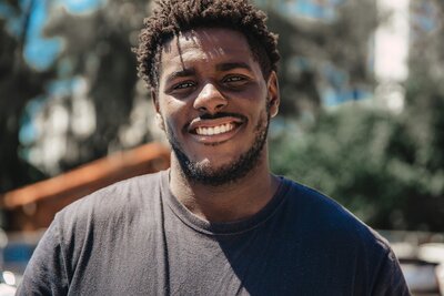 a black young male smiling to the camera after a coaching session