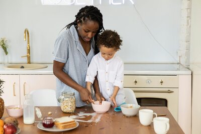 Mother and son baking together at wooden table | Rooted Within family connection and parent guidance sessions