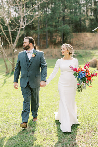 Wife holding her pregnant belly and her husband's hand