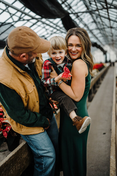 Young family hugging on hillside in fall in Wisconsin.
