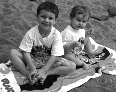 Black and white family photography of two kids sitting on a beach