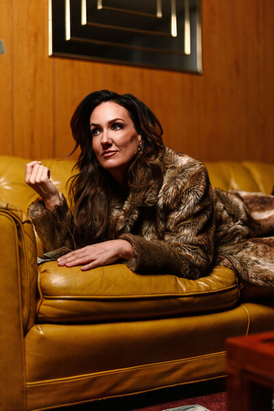 Brand Photoshoot of Juliet Trnka-on a mustard yellow couch-Direct Knowing Brand Photo session
